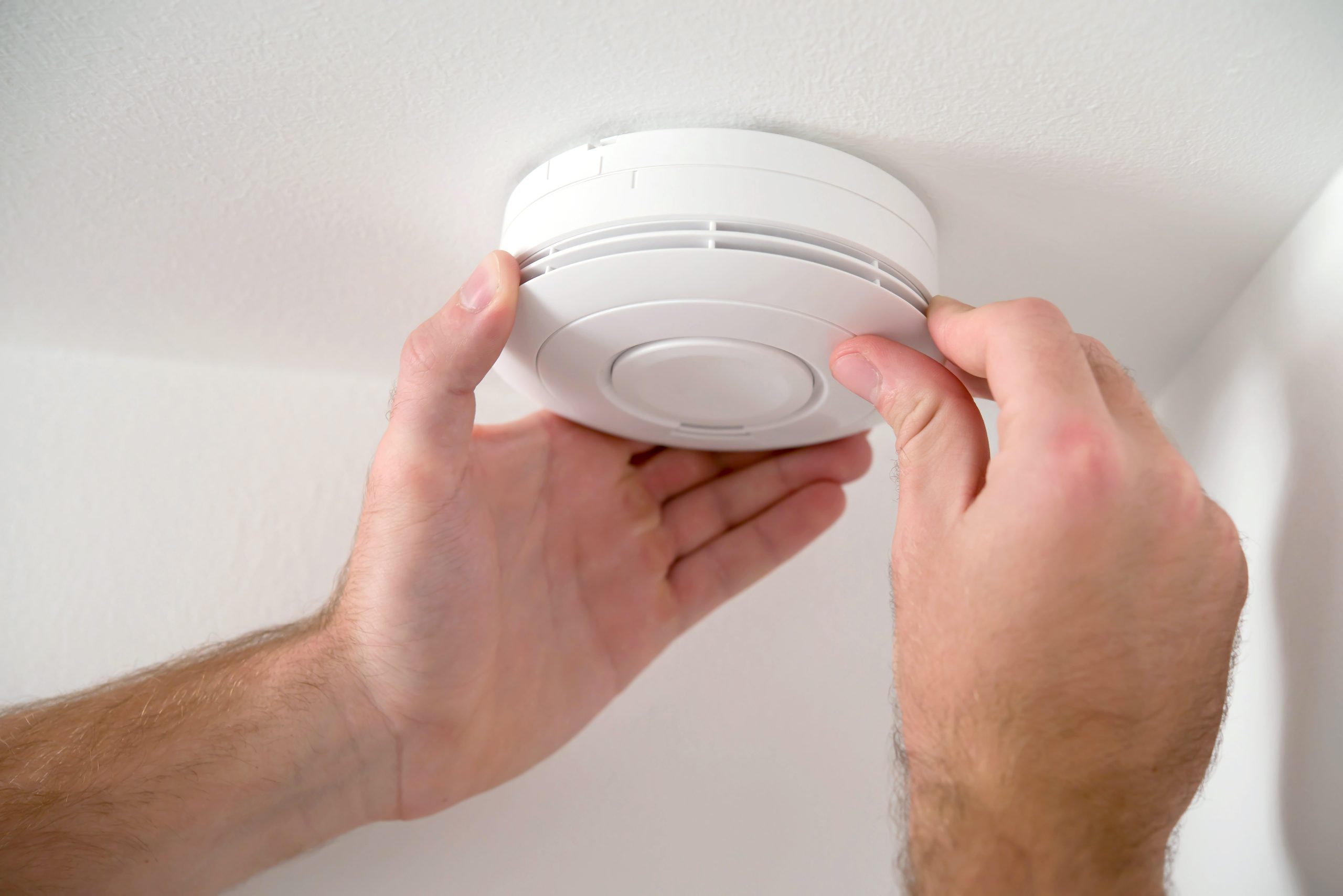 Man installing smoke or carbon monoxide detector