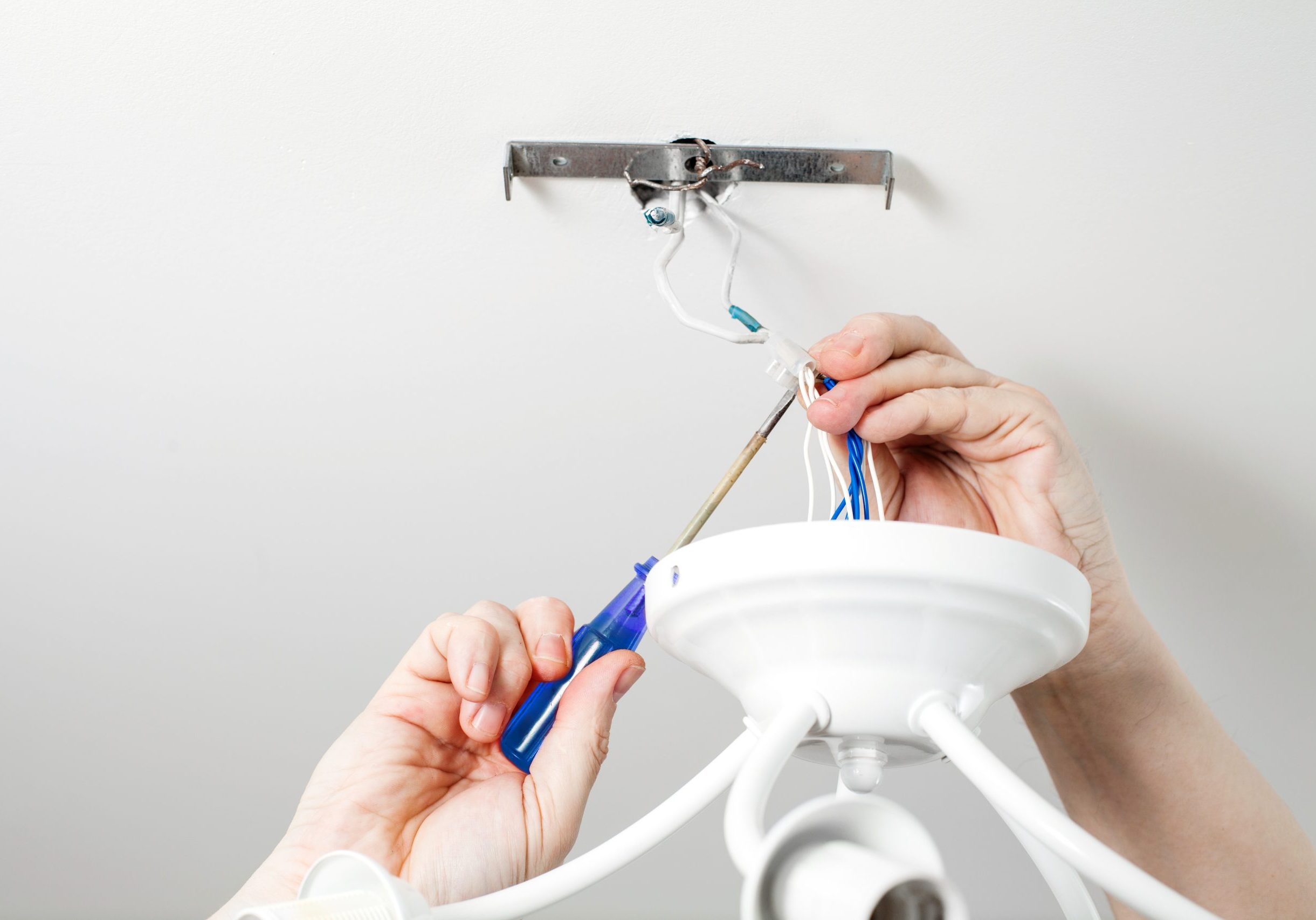 Electrician repairing chandelier in the house